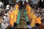 Para biksu agama Budha berjalan di antara para tentara dan sanak saudara dari mereka yang terbunuh di provinsi Yala yang bergolak di Thailand selatan pada tanggal 21 Januari. Ratusan biksu dari 200 kuil lebih menyumbangkan makanan dan berdoa bersama dengan sanak saudara para korban yang terbunuh dalam kekerasan yang terjadi pada akhir pekan Tahun Baru Imlek. [Reuters]