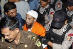 Terdakwa perakit bom Umar Patek terlihat di sini sedang dikawal menuju pengadilan pada awal persidangannya di Jakarta Barat, 13 Februari. Tim pengacaranya berkilah bahwa dia bukan bagian dari rencana untuk melancarkan pembunuhan massal di Bali. [Reuters]