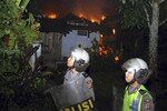 Anti-riot police view a burning house owned by followers of the minority Ahmadiyah sect, in Ciampea in West Java province, in October 2010. Neighbouring Muslims critical of Ahmadiyah allegedly set the blaze. Indonesian lawmaker Eva Kusuma Sundari has called for the national police force to do more to protect religious minorities. [Reuters] 