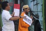 Umar Patek (kanan) tertuduh pembuat bom Jemaah Islamiyah, ambil bagian dalam rekonstruksi bom Bali 2002 tahun lalu. Pihak berwenang dalam kasus penyidangan Patek menyatakan pengecekan harus diperketat untuk mencegah kaburnya para tersangka teror, seperti yang dilakukan Patek pada tahun 2009 ketika dia buron ke Pakistan. [Reuters]