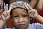 Seorang bocah Muslim turut serta dalam unjuk rasa yang menuntut dihentikannya kekerasan di Filipina. Program penanggulangan kemiskinan di negara itu bertujuan memberdayakan komunitas setempat, menuntut tanggung jawab pembuatan keputusan ada di tangan para penduduk setempat. [Romeo Ranoco/Reuters] 
