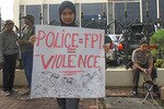 Seorang pendukung Indonesia Tanpa FPI memegang poster di sebuah unjuk rasa yang diikuti oleh sekitar 50 orang di depan Markas Besar Kepolisian Nasional di Jakarta pada tanggal 10 Mei 2012. Kelompok ini menuntut penghentian kekerasan yang dilakukan atas nama agama. [Elisabeth Oktofani/Khabar]