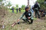Para penyelidik kepolisian Thailand mengumpulkan sisa-sisa jenazah Sagareeya Masang, seorang warga subdistrik Korlum, yang tewas dalam sebuah ledakan di perkebunan kelapa di Pattani. Ayahnya, Meulee Masang, diberi tahu mengenai kematian putranya dari teman-temannya di sekolah. [Bas Pattani/Khabar]