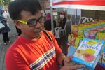 Daree Sa-ah memperlihatkan kotak puding Dadih dari Malaysia di Phuket Andaman Halal untuk Pariwisata 2013, acara tahunan yang kelima. Dia datang untuk membeli produk yang ia tahu halal secara otentik. [Somchai Huasaikul/Khabar]