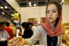 Seorang wanita menawarkan sampel buah kurma asal Iran di Pameran Halal Internasional Malaysia di Kuala Lumpur pada Mei 2007. Penegakan kebijakan terbaru yang menargetkan penyelundup narkoba dan imigran ilegal telah berdampak pada warga Iran yang bekerja atau belajar di Malaysia. [Tengku Bahar/AFP]